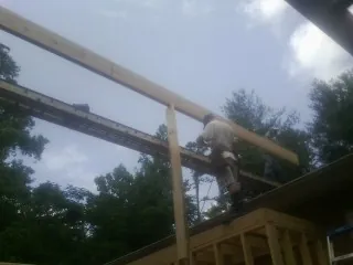 Carpenter setting a ridge beam over a new addition frame — Ice Dam Removal by Roofing Brothers in Encino