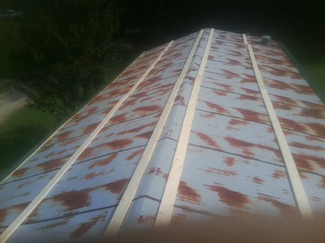 Rusted metal roof panels with new wood purlins before replacement — Storm Damage Roof Repair in Encino by Roofing Brothers