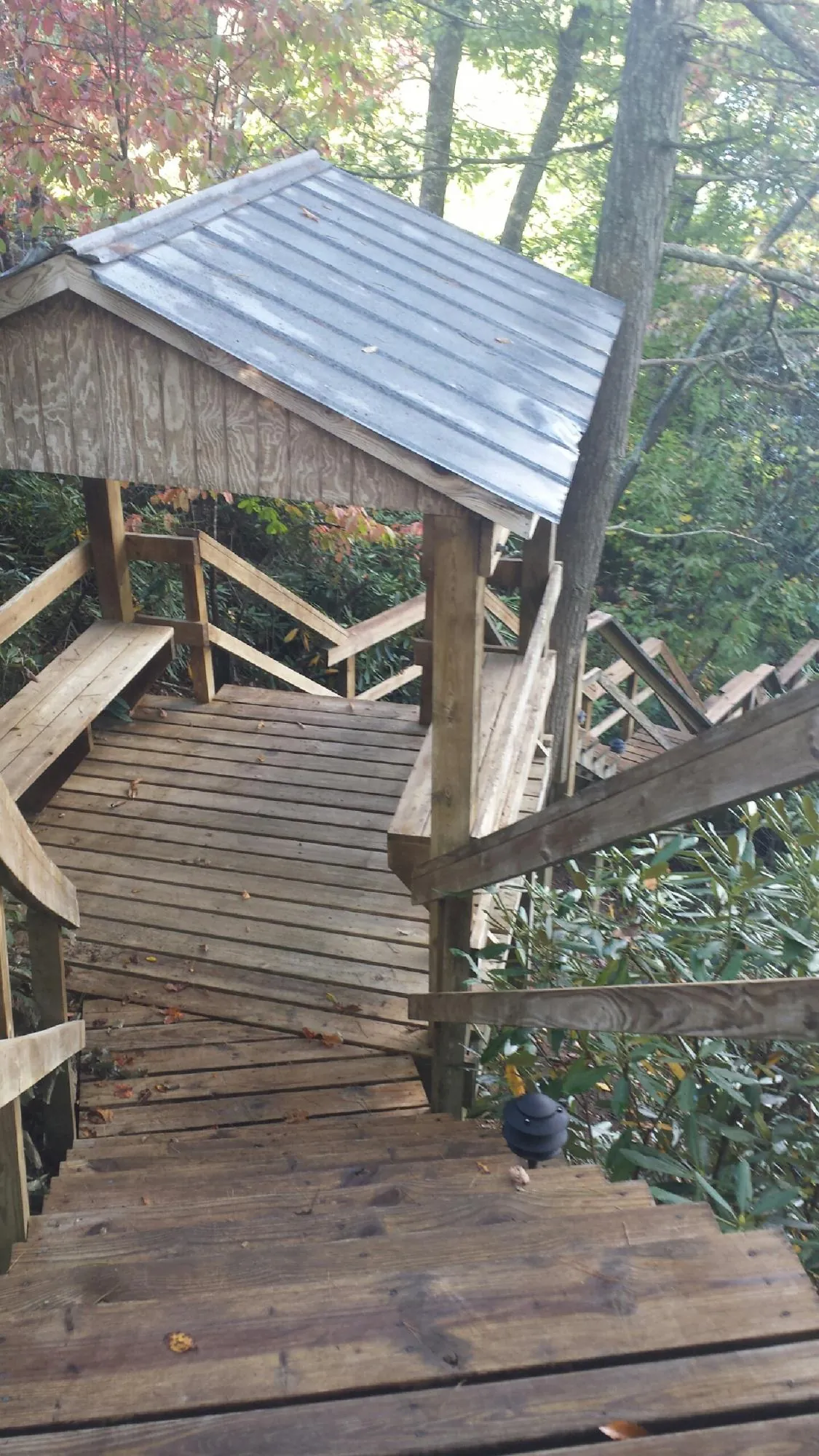 Metal roofed shelter over wooden steps on a wooded walkway — Skylight Repair & Installation work by our crew in Encino