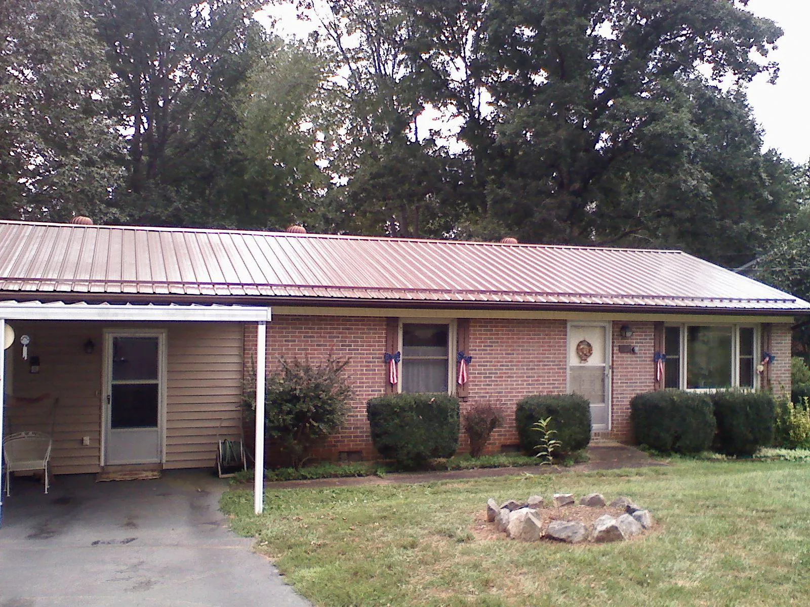 Bronze metal roof and carport on a brick ranch home — Roof Repair work by our crew in Encino